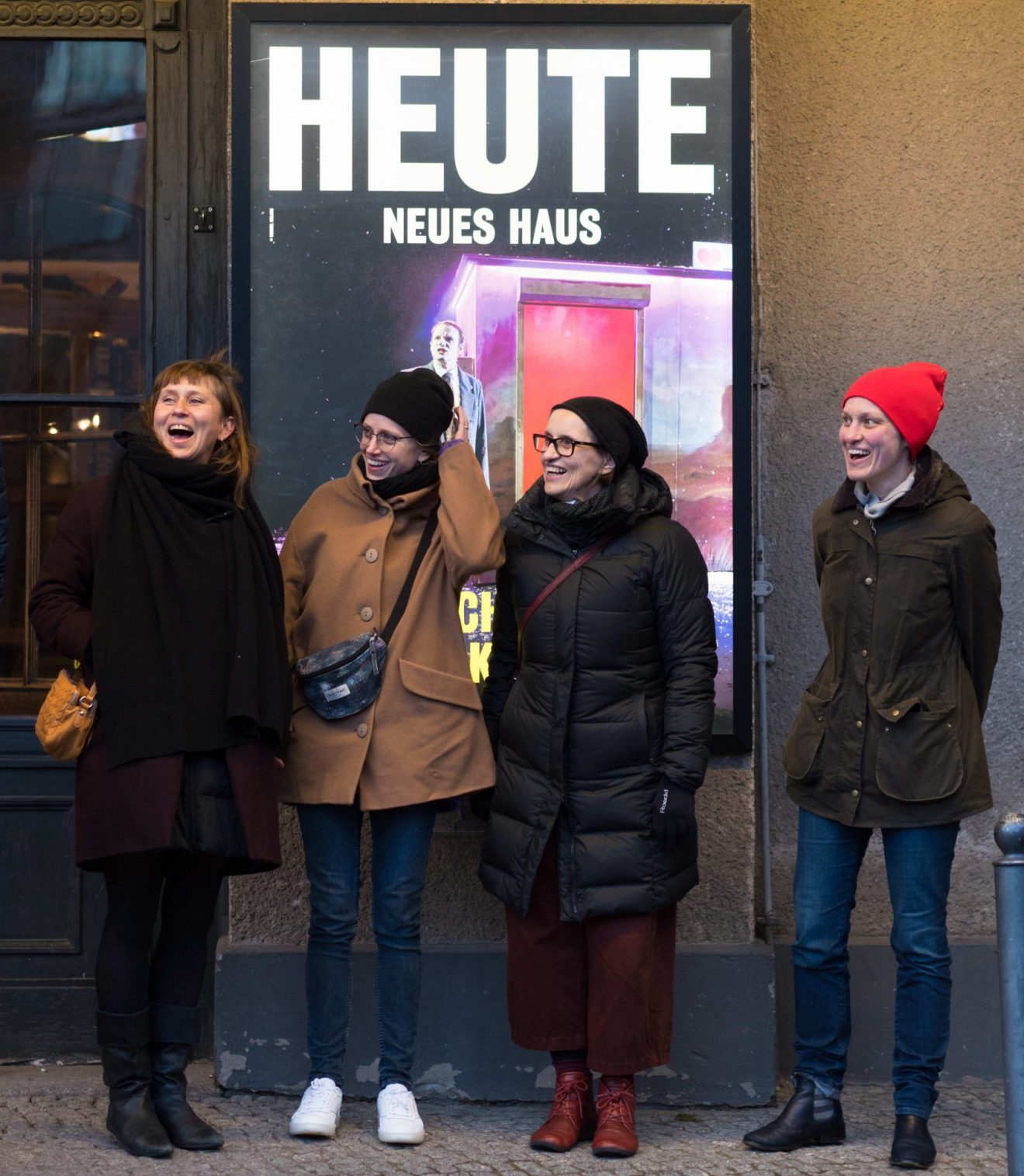 Katrin, Mascha, Susanne und Manja stehen vor dem Berliner Ensemble, im Hintergrund ein Plakat mit dem Text: HEUTE NEUES HAUS