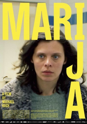 Das Bild zeigt das Filmplakat von "Marija". Man sieht eine junge dunkelhaarige Frau mit blauen Augen, die an der Foto-Linse vorbei blickt. Sie trägt einen grünen Pullover und eine graue Jacke aus Kunstpelz oder Fleece. Ihr Gesichtsausdruck ist unbestimmt.